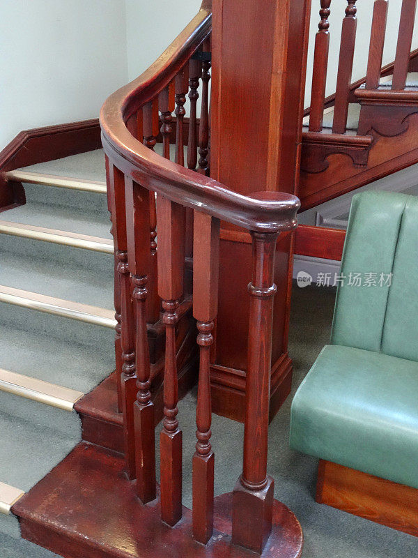 木制楼梯扶手/主轴，楼梯，绿色地毯，金属边的图像